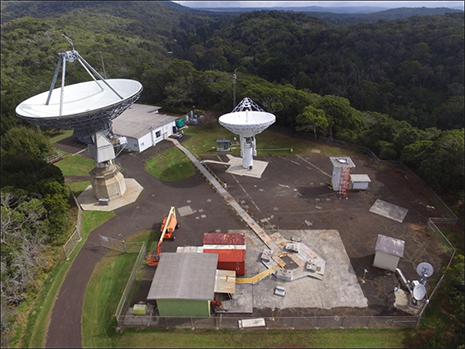 An aerial view of the Kokee Park Geophysical Observatory (KPGO) located in Kokee State Park on Kauai Island.  The new 12-meter antenna system is shown at center.  The older, larger 20-Meter antenna (left) has been supporting NASA earth and climate scientific research for over 30 years but will eventually be decommissioned and removed once the next-generation VLBI Global Observing System is fully operational and replaces the legacy VLBI network.